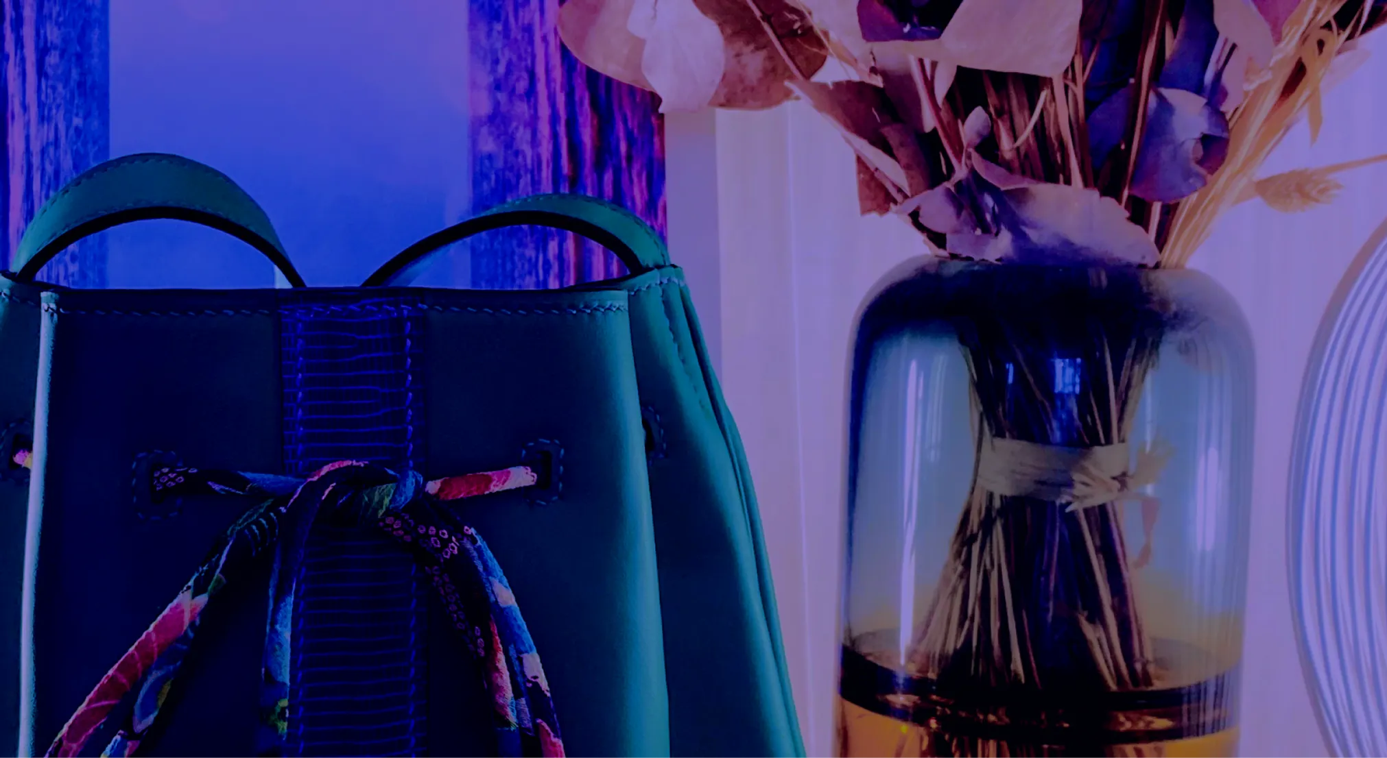 Sac en cuir Atelier Idéal posé au milieu d'une composition florale